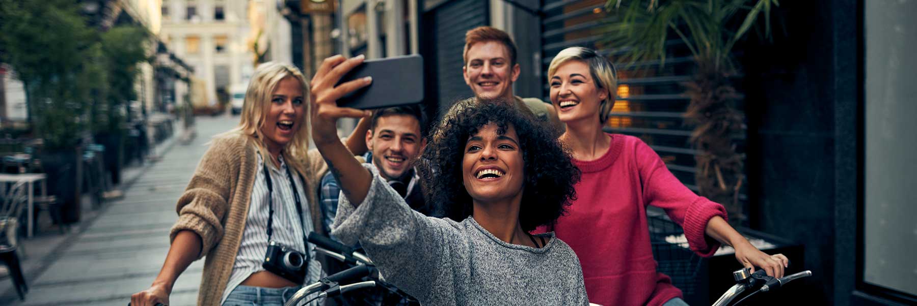 Image d'un groupe d'amis à bicyclette sur le trottoir prenant un égoportrait